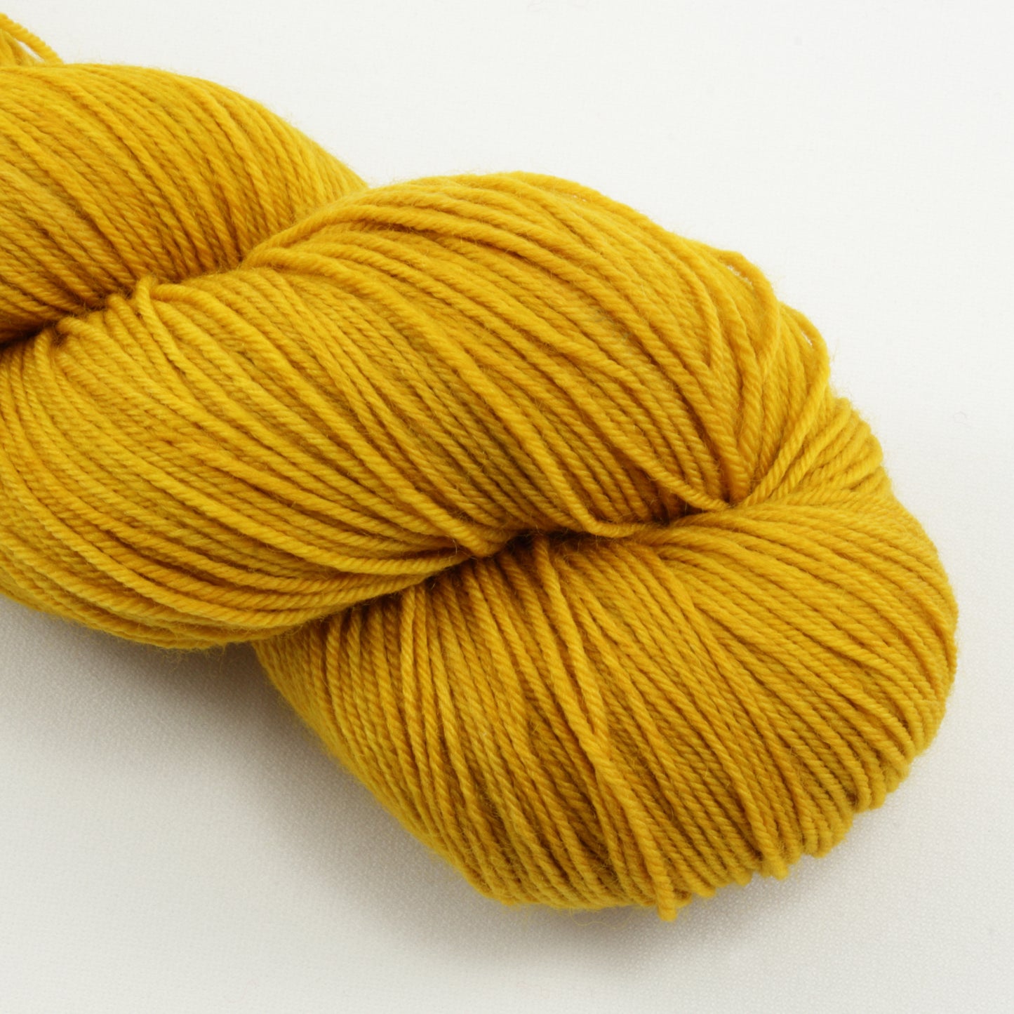 Yellow skein of yarn on a white background