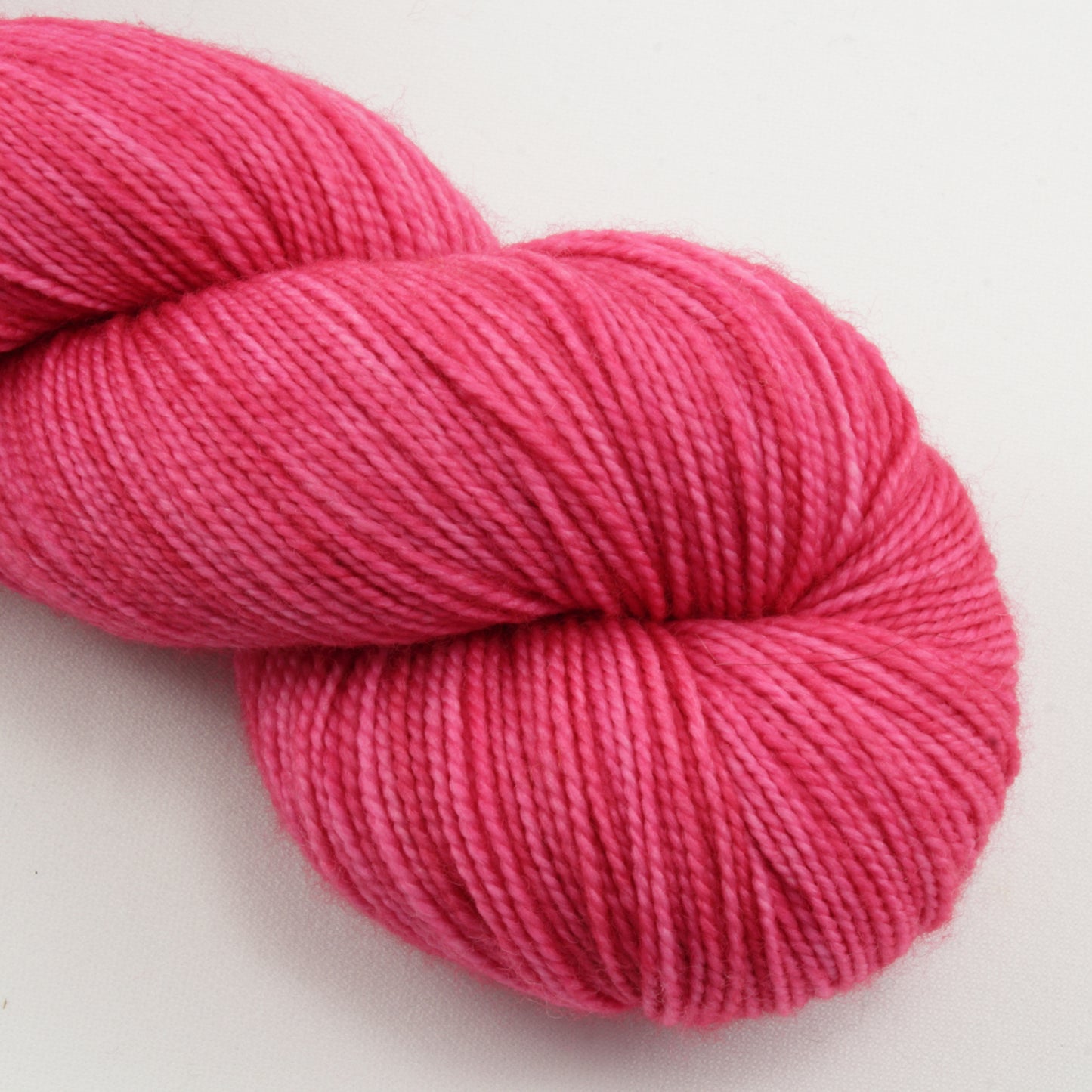 Pink skein of yarn on a white background